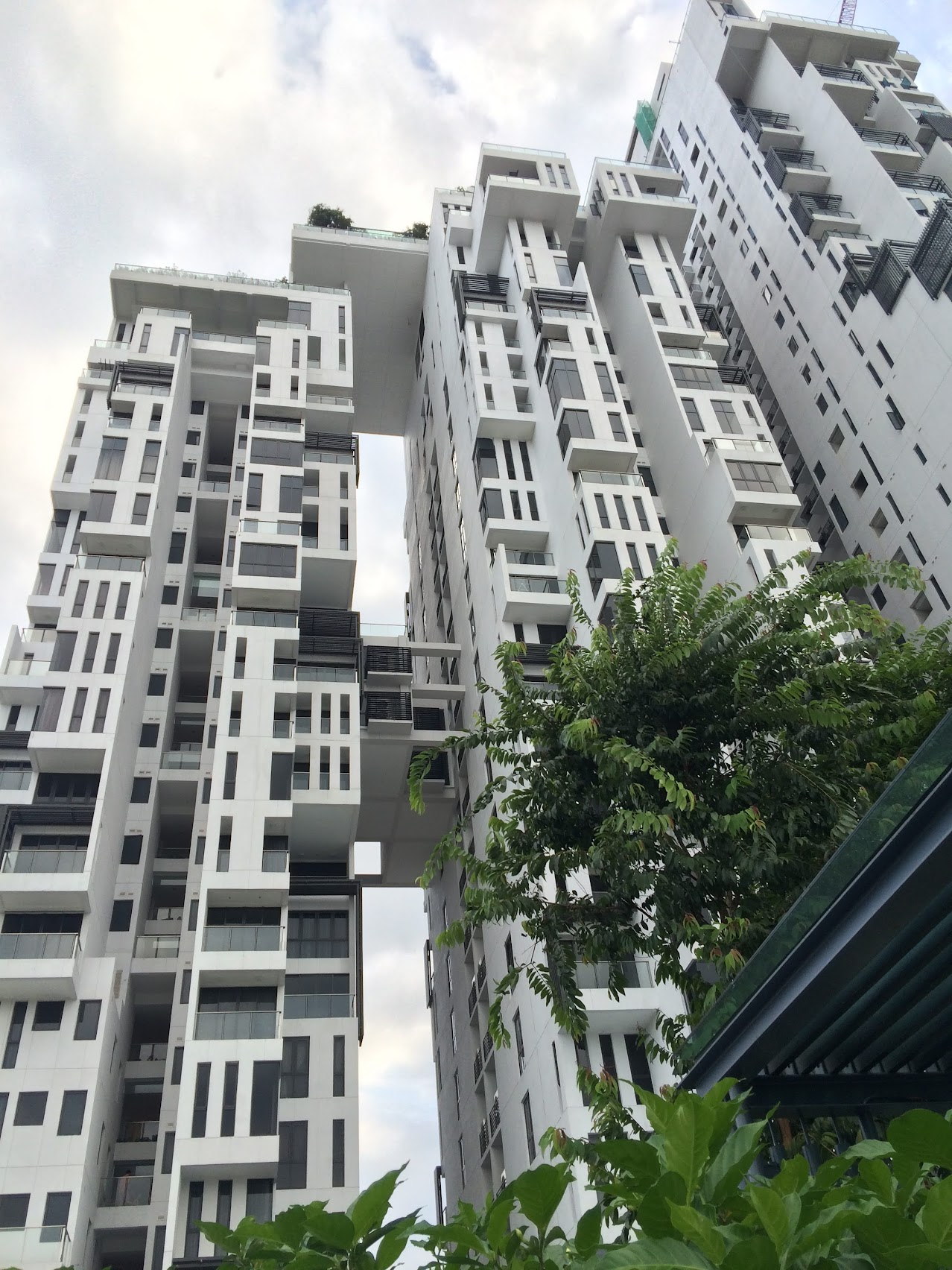 Joyce’s photograph looking up at The Icon Residence’s stepped white towers, balconies, and planting