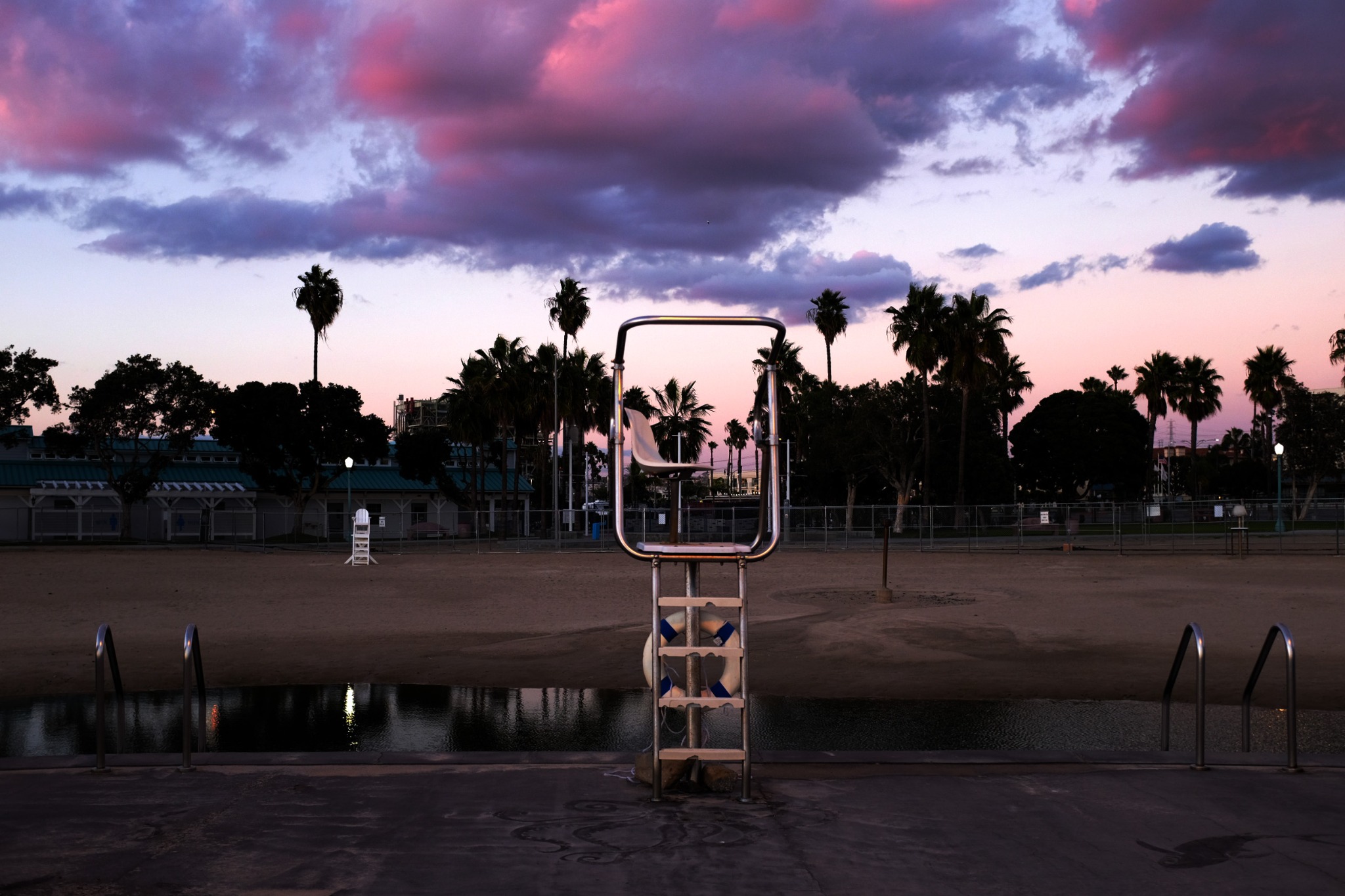 An empty lifeguard chair under a violet evening sky in Los Angeles.