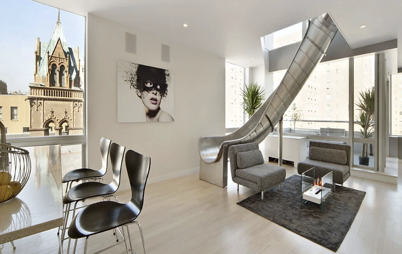 East Village penthouse interior with furnishings around the existing sculptural steel slide.